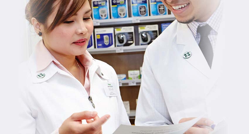 Pharmacists talking together while looking at a paper