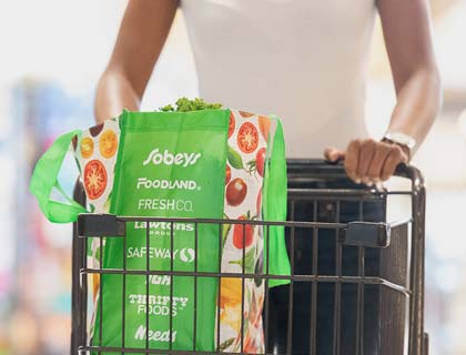 Customer with a cart and Sobeys reusable bag shopping